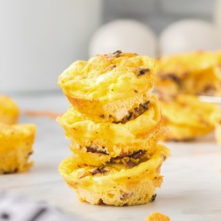 A stack of three mini egg muffins with bacon