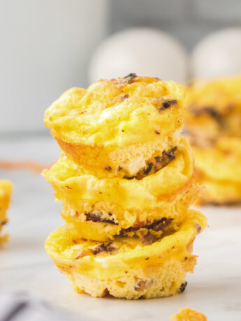 A stack of three mini egg muffins with bacon