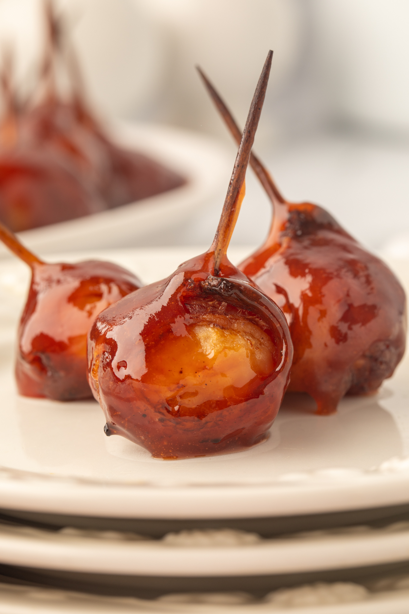 a picture of bacon wrapped water chestnuts on a plate with toothpicks