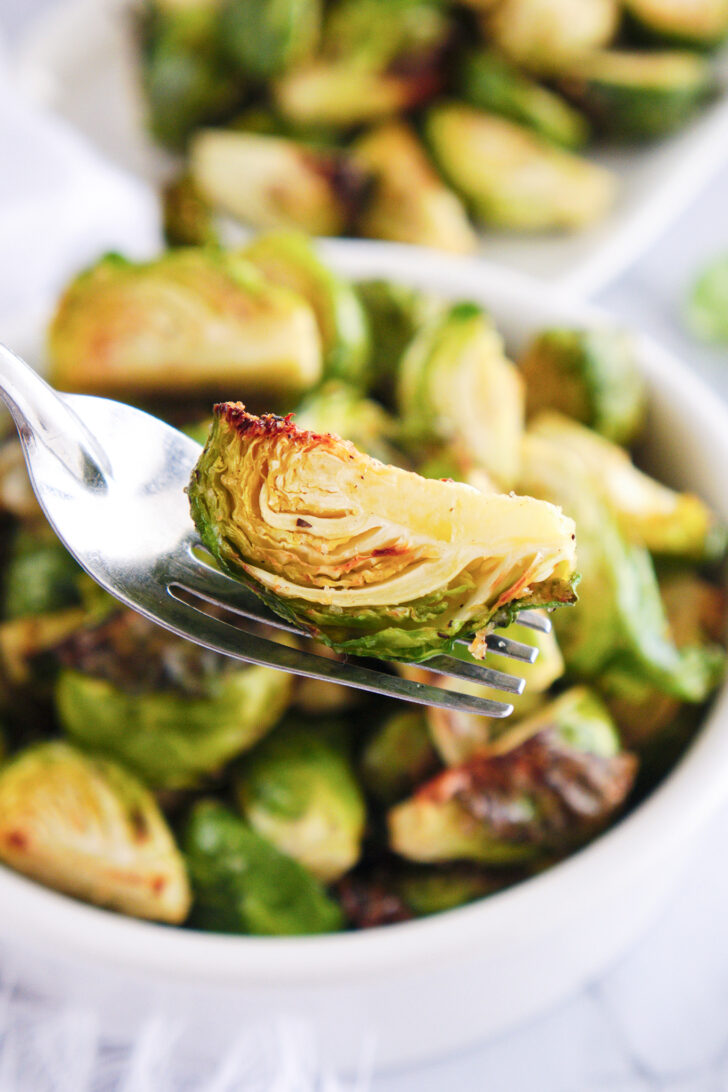 a photo of a roasted brussels sprout on a fork