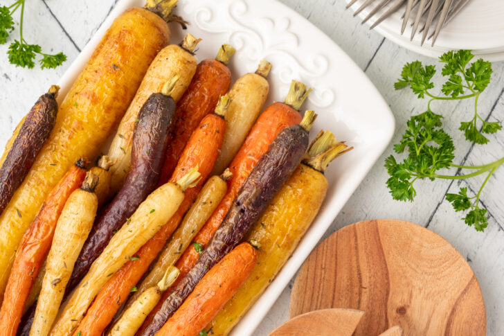 a photo of roasted rainbow carrots on a white platter