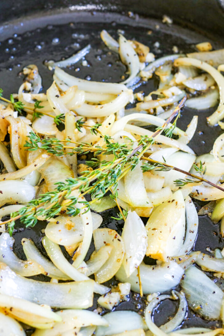 a photo of onions being sauteed in a cast iron skillet