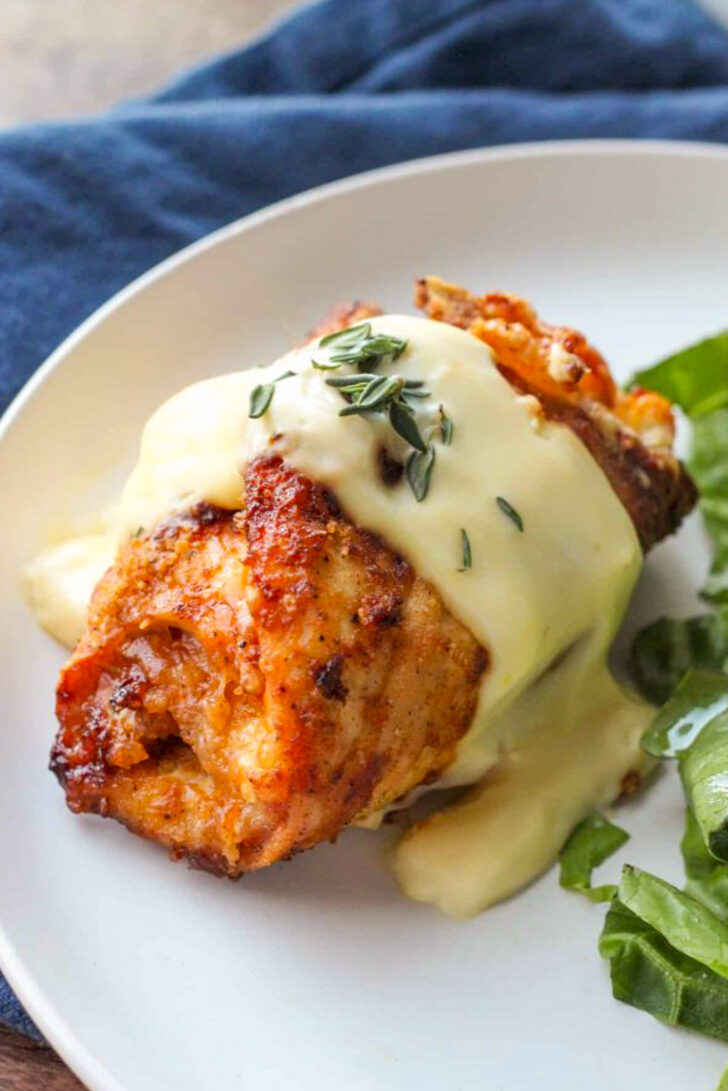 a photo of chicken cordon bleu on a white plate