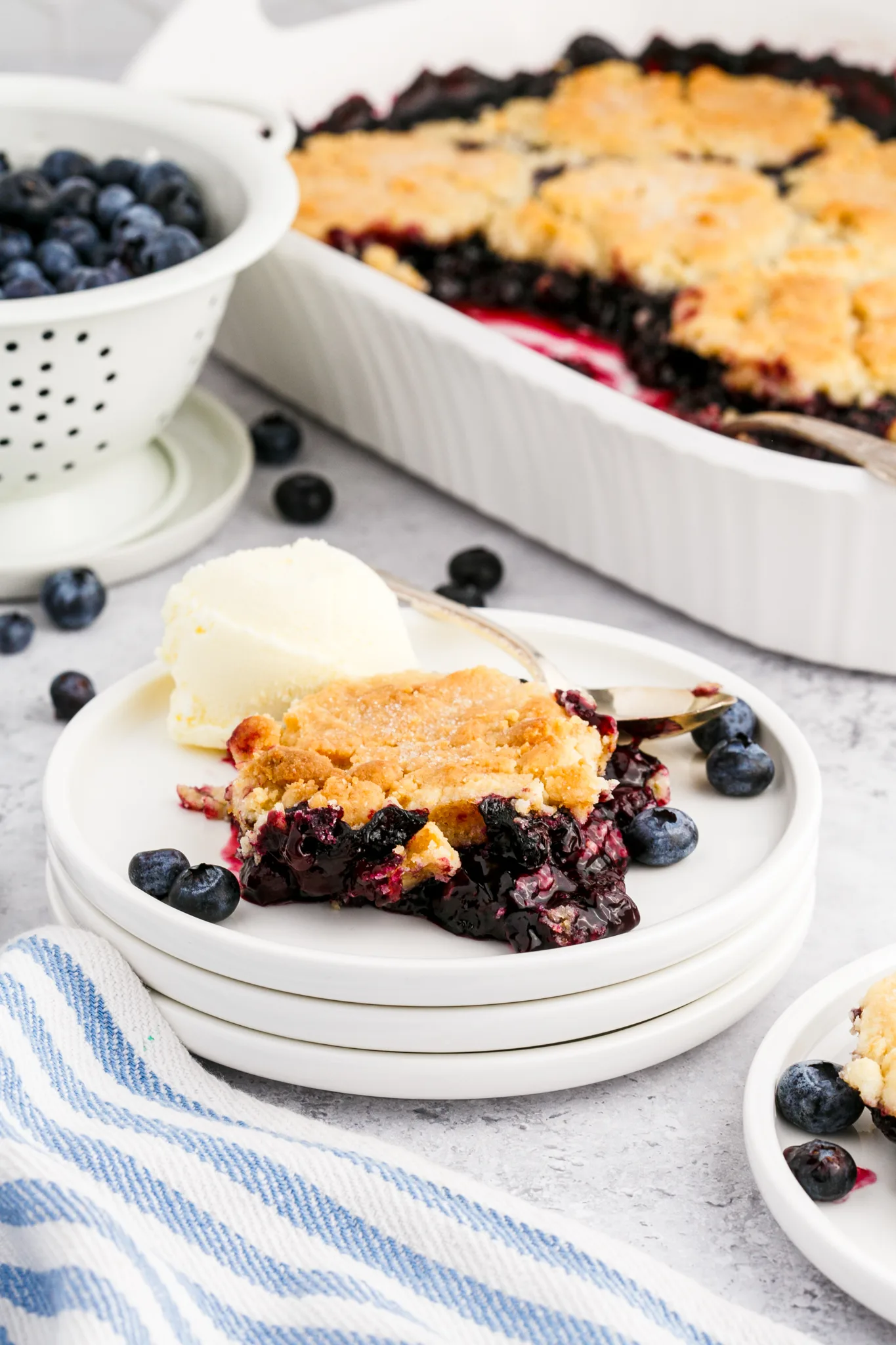 a photo of blueberry cobbler on a white plate