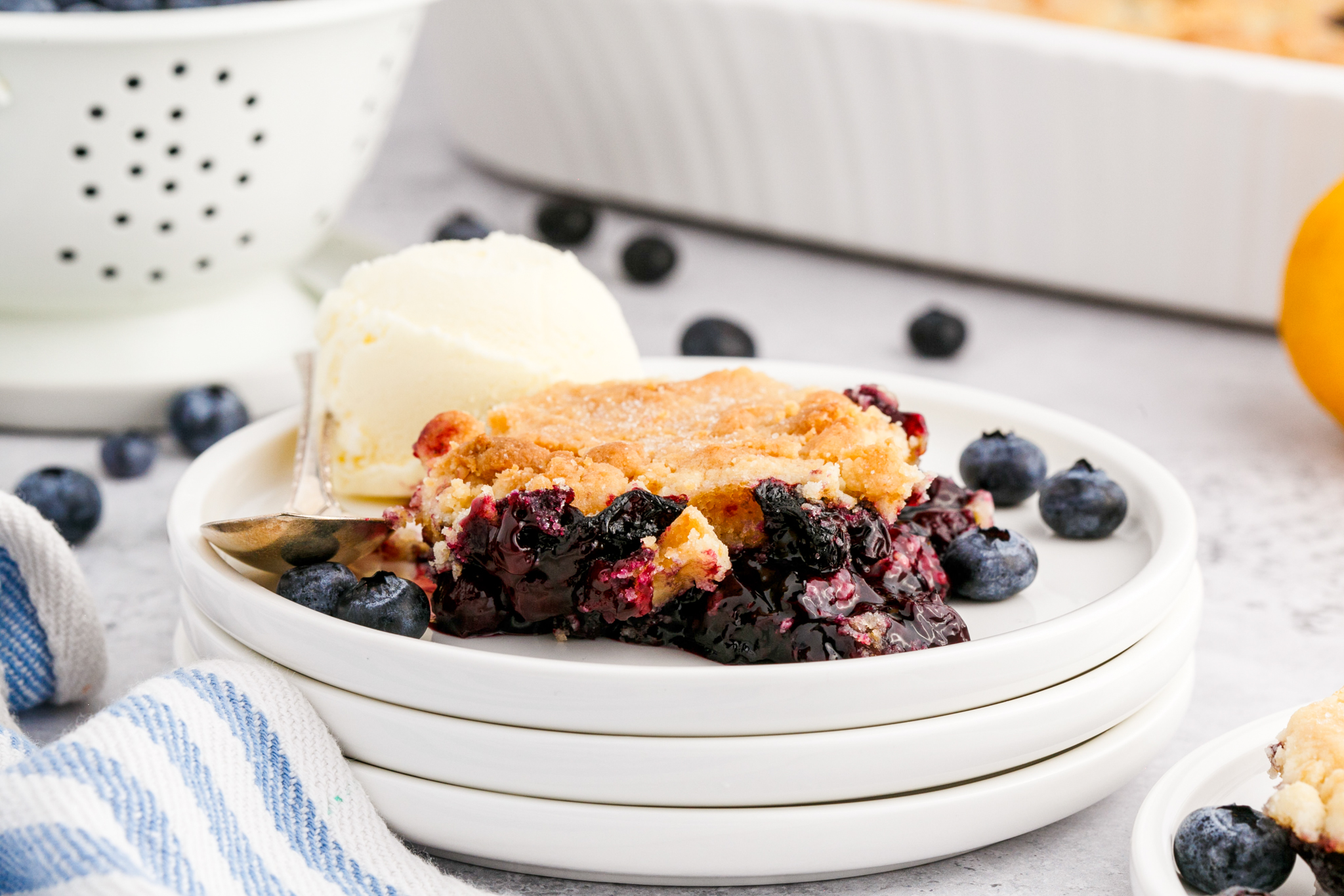 a photo of blueberry cobbler and ice cream on a white plate