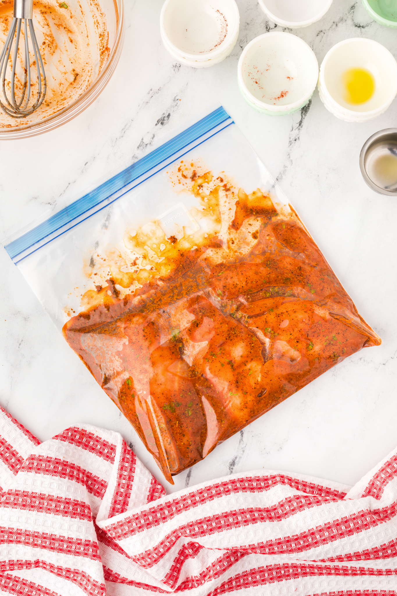 a photo of raw chicken in pollo asada marinade in a Ziploc bag