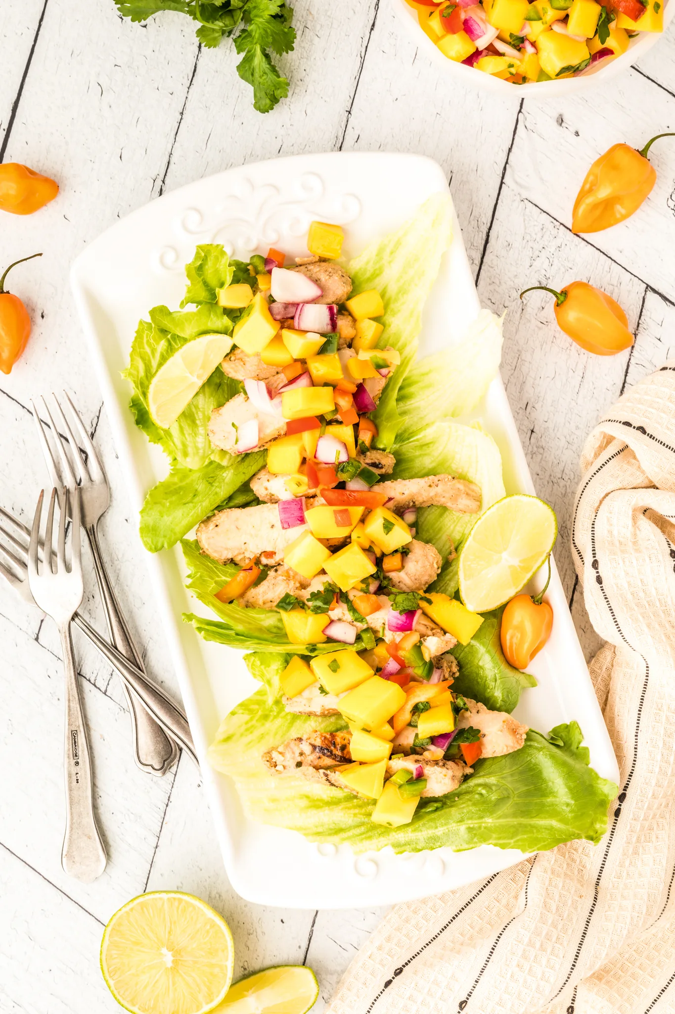 A photo of mango habanero salsa on top of chicken lettuce wraps