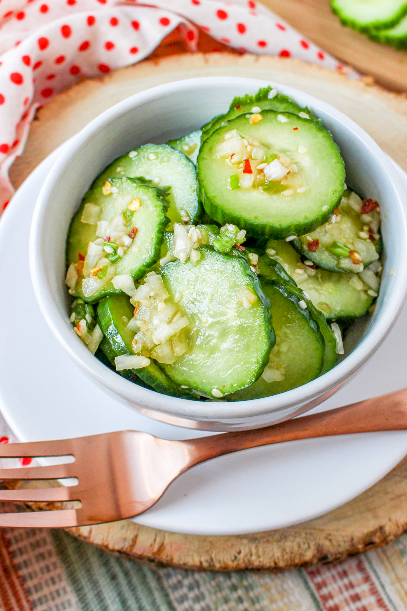 a photo of cucumber slices in an asian vinaigrette in a bowl