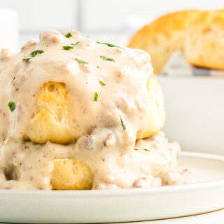 A photo of biscuits and gravy on a white plate