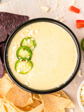 an overhead photo of white queso dip topped with jalapenos