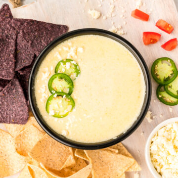 an overhead photo of white queso dip topped with jalapenos