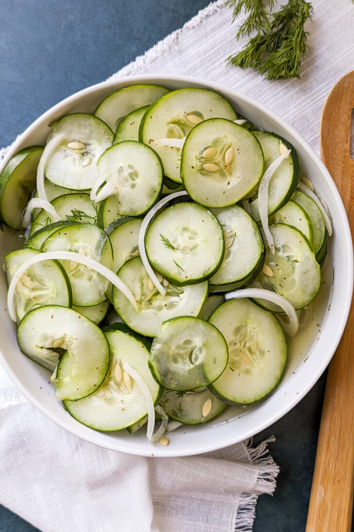 an overhead photo of a bowl of cucumber salad with onions