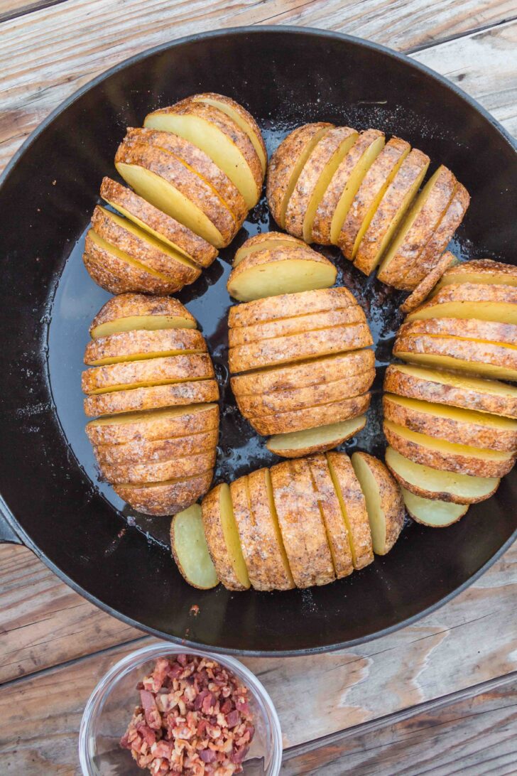 a photo of hasselback potatoes in a cast iron skillet