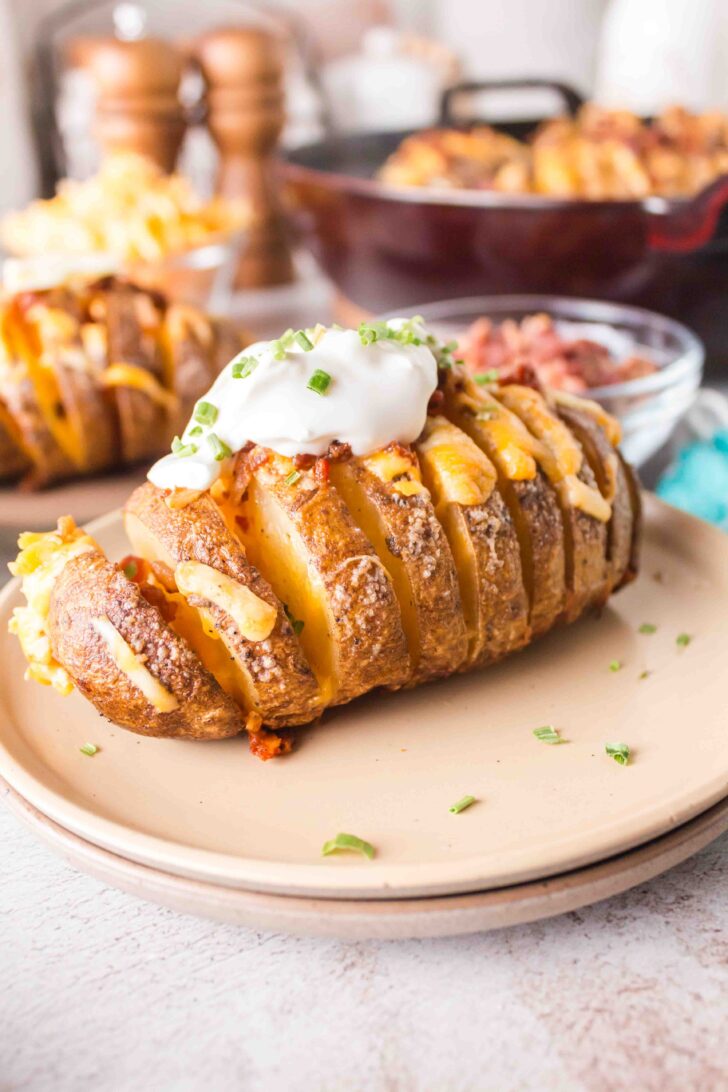 a photo of a smoked hasselback potatoes with sour cream on top