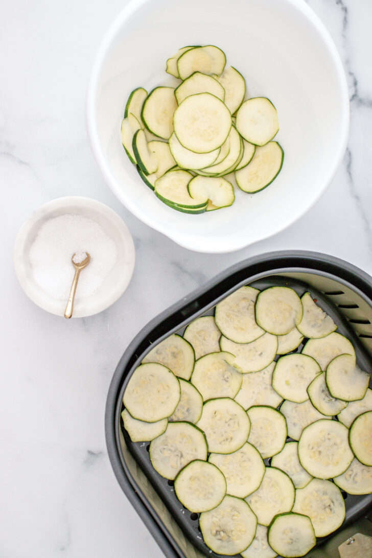 a photo of zucchini slices in the air fryer basket