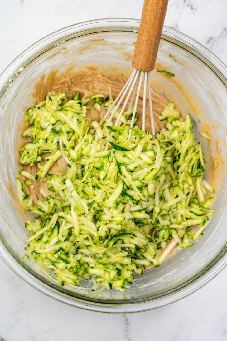 shredded zucchini into zucchini muffins batter
