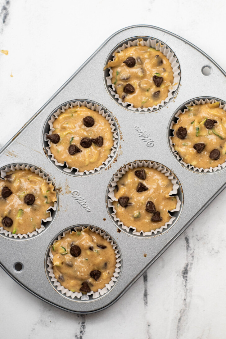 zucchini muffin batter in a muffin tin