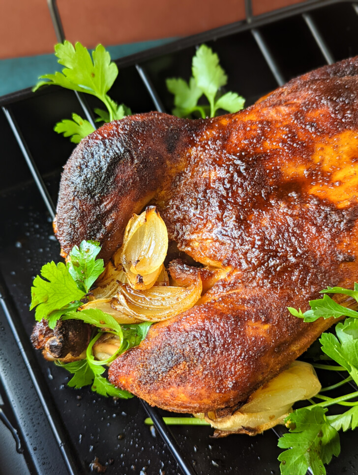 a close up photo of a roasted chicken with garlic cloves