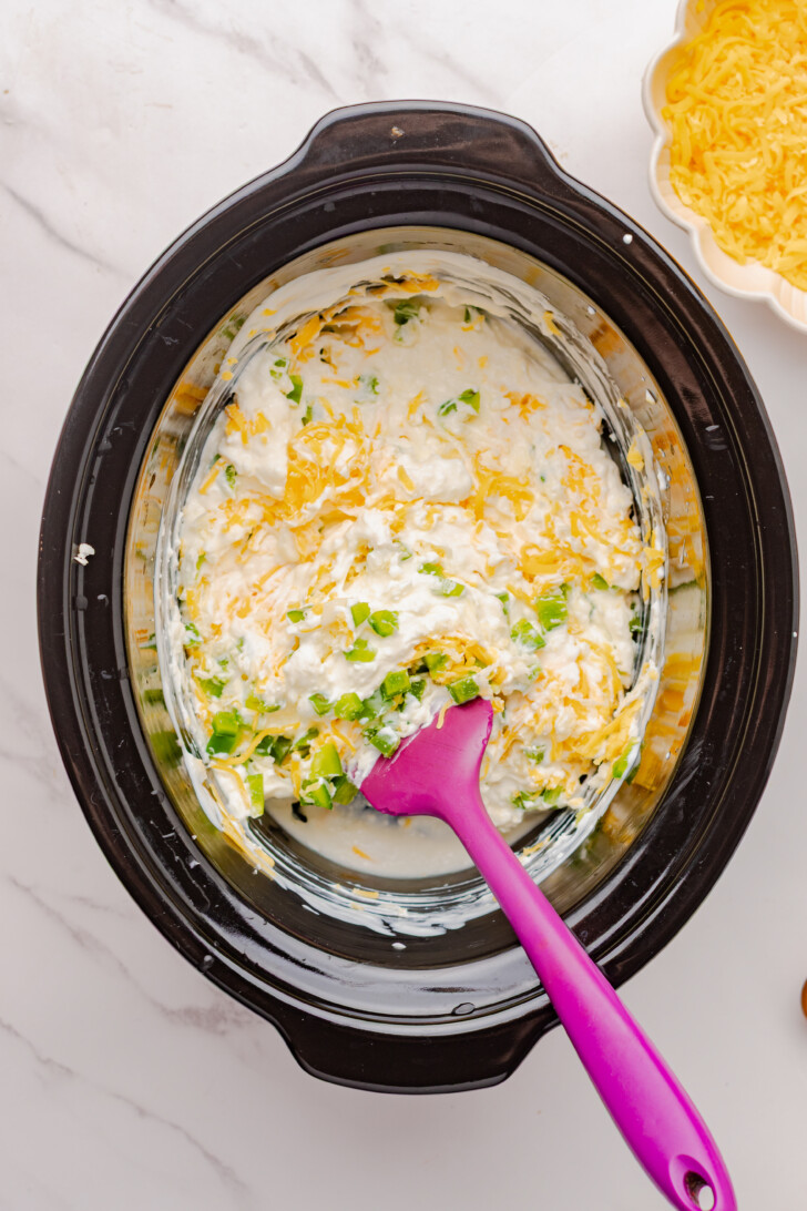 jalapeno popper dip mixture being stirred by a spatula