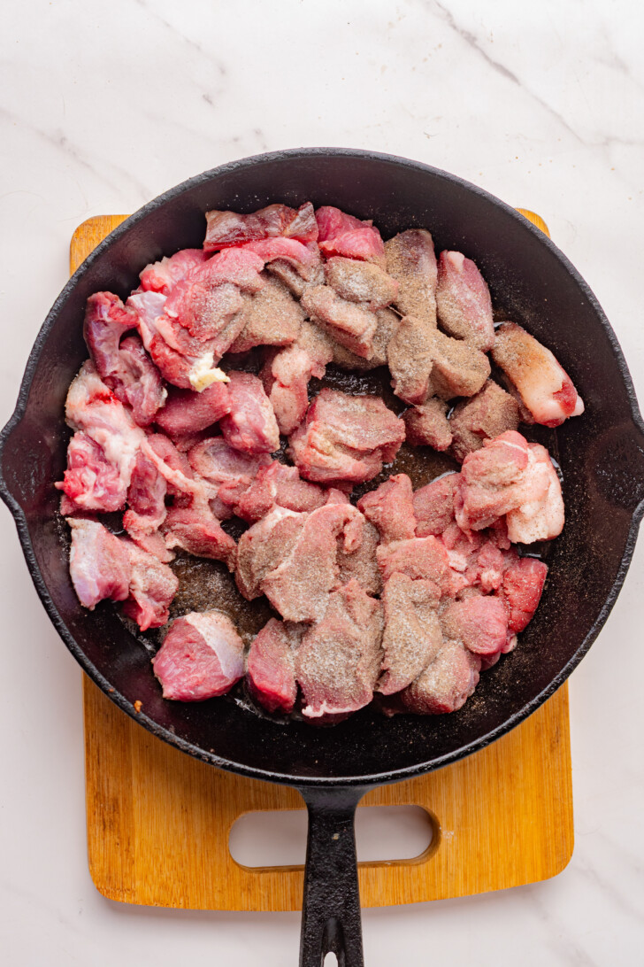 steak bites searing in a cast iron skillet