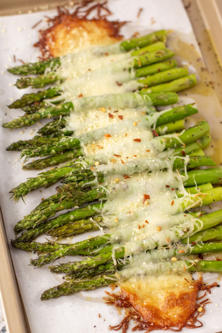 baked asparagus with cheese on a tray