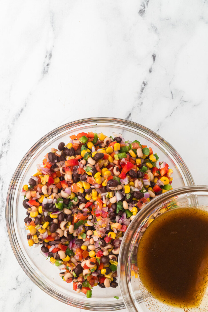 pouring dressing on a bean salad