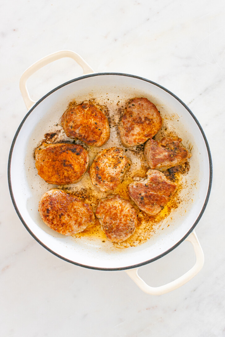 pork medallions searing in oil in a dutch oven