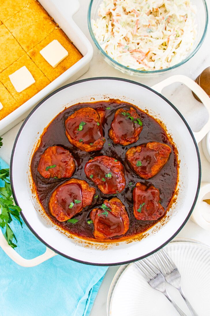 a Dutch oven filled with pork medallions and barbecue sauce
