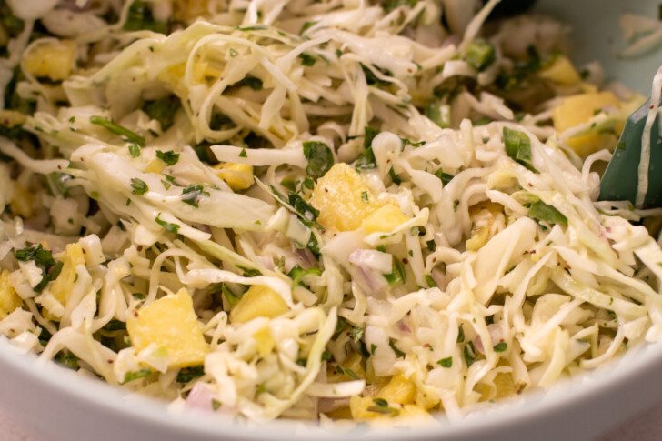 a horizontal photo of pineapple slaw in a bowl