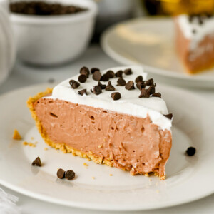 a slice of chocolate cream pie topped with whipped cream and chocolate chips