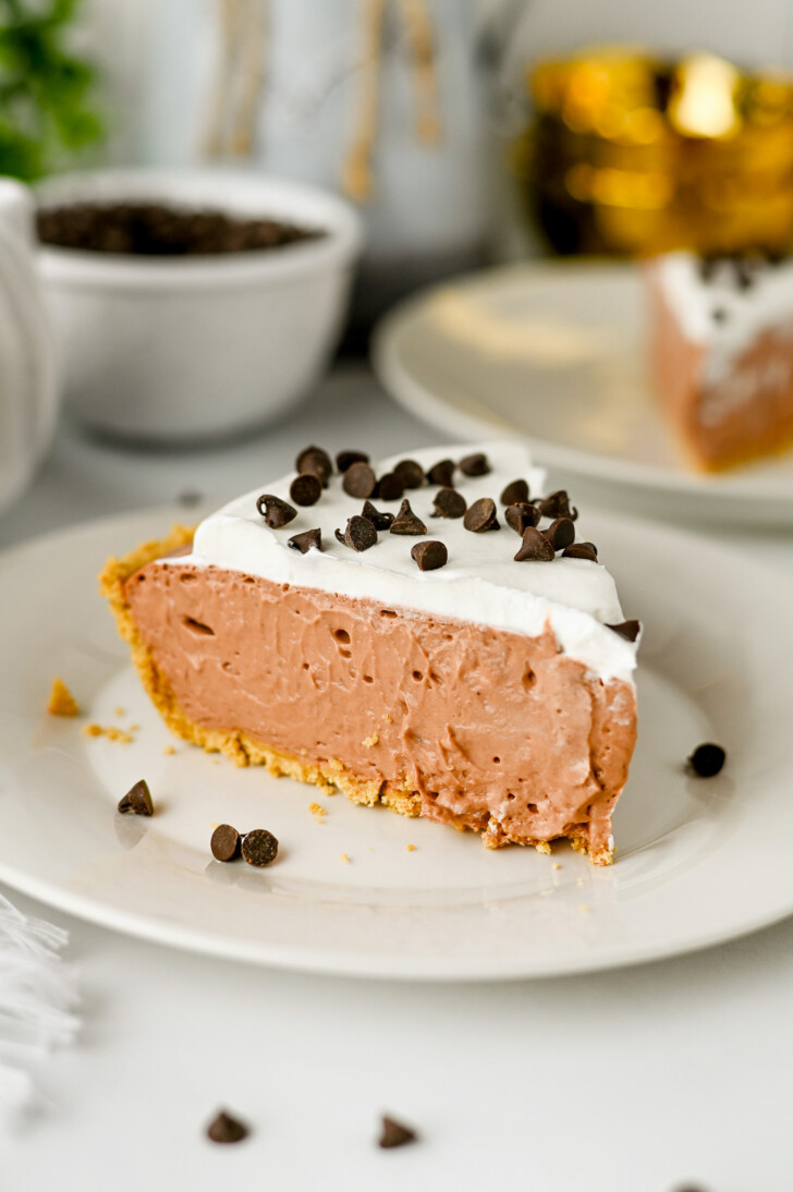 a slice of chocolate cream pie topped with whipped cream and chocolate chips