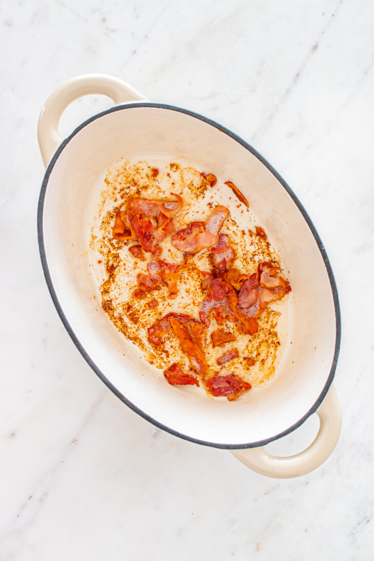 bacon pieces sauteeing in a dutch oven