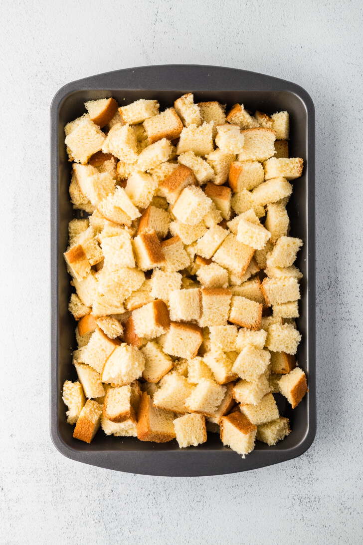 torn pieces of bread in a casserole dish
