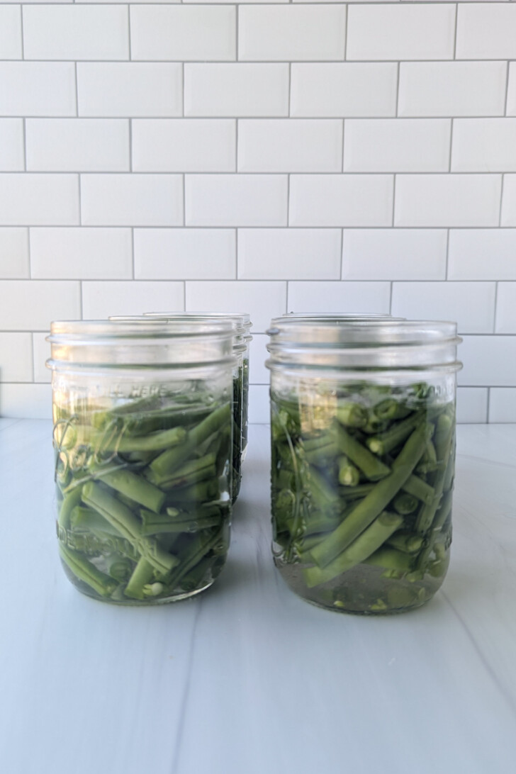 several glass jars filled with canned green beans