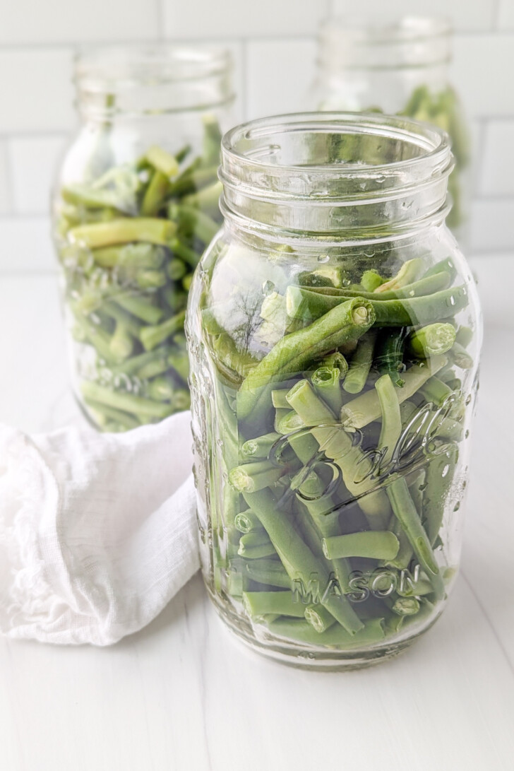 a glass jar filled with fresh green beans