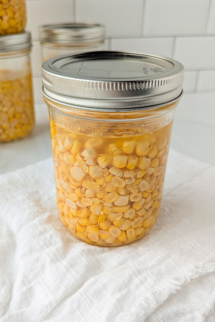 a jar filled with corn kernels and water