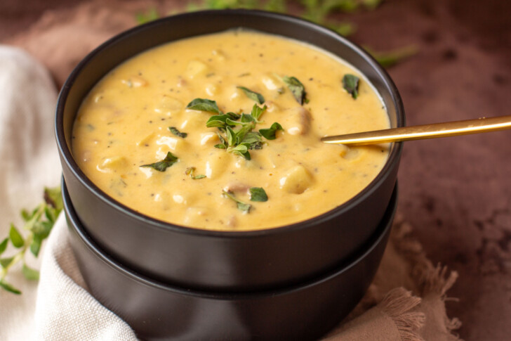 a black bowl filled with cheese potato and ham soup