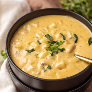 a black bowl filled with cheesy ham and potato soup