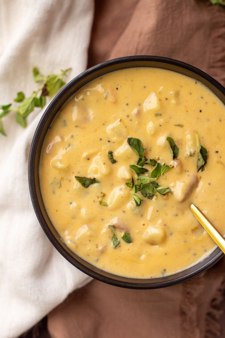 a black bowl filled with a cheesy soup