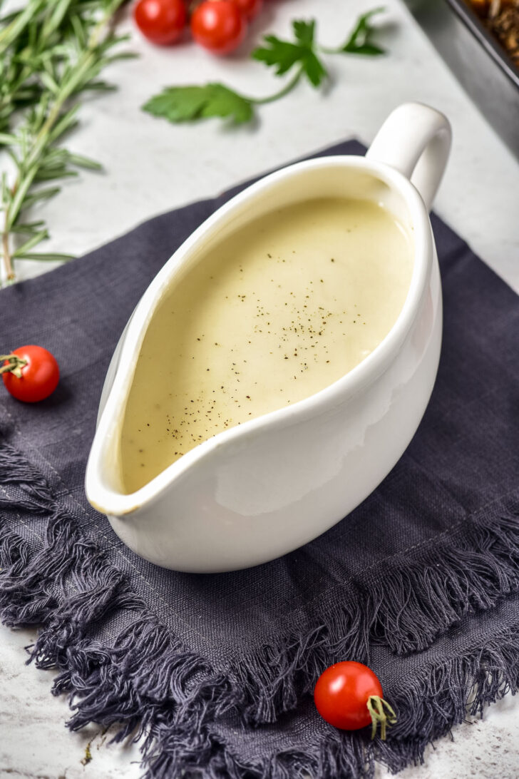 turkey gravy in a gravy boat surrounded by vegetables