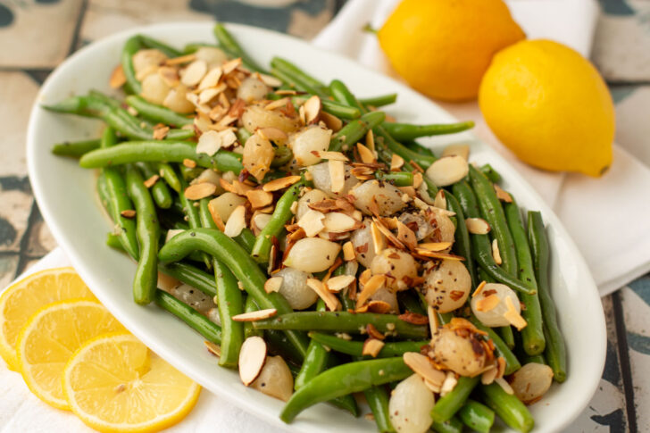 a white platter filled with fresh green bean amandine